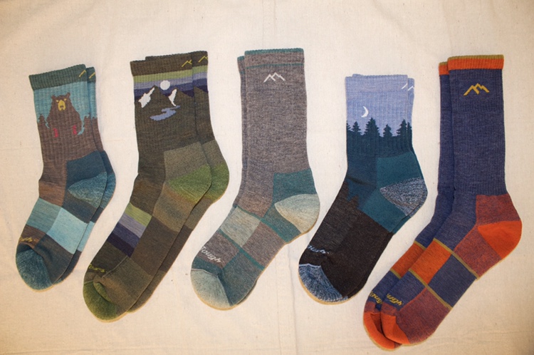 5 Pairs of Darn Tough socks laid out on a canvas background.