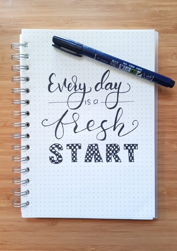 A notebook with cursive writing that says everyday is a fresh start. A good reminder for how to build discipline.