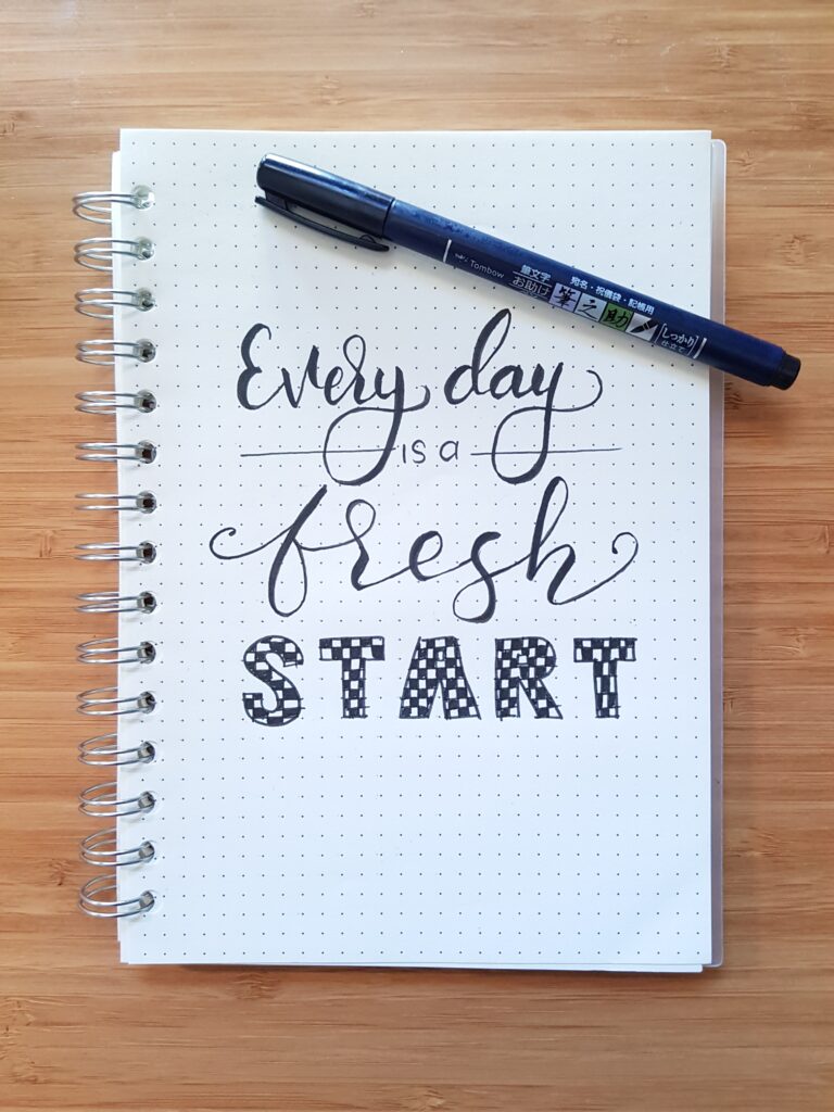 A notebook with cursive writing that says everyday is a fresh start. A good reminder for how to build discipline. 
