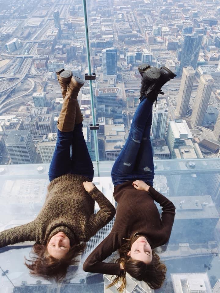 Mom and daughter laying down on the Chicago Skydeck ledge.