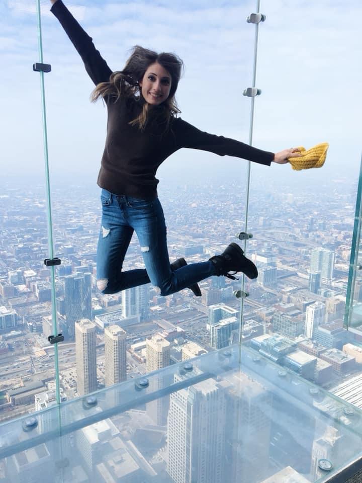 Girl jumping in the Chicago Skydeck glass box.