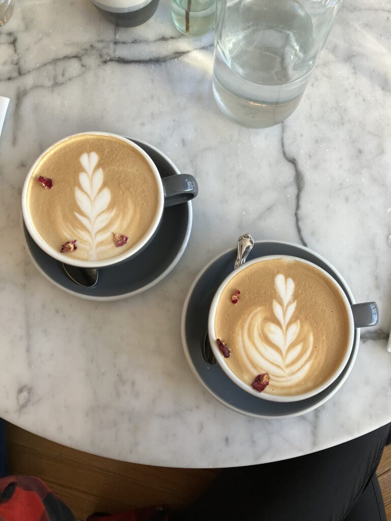 Two Rose Lattes sitting on the marble table top at Cafe Roze.