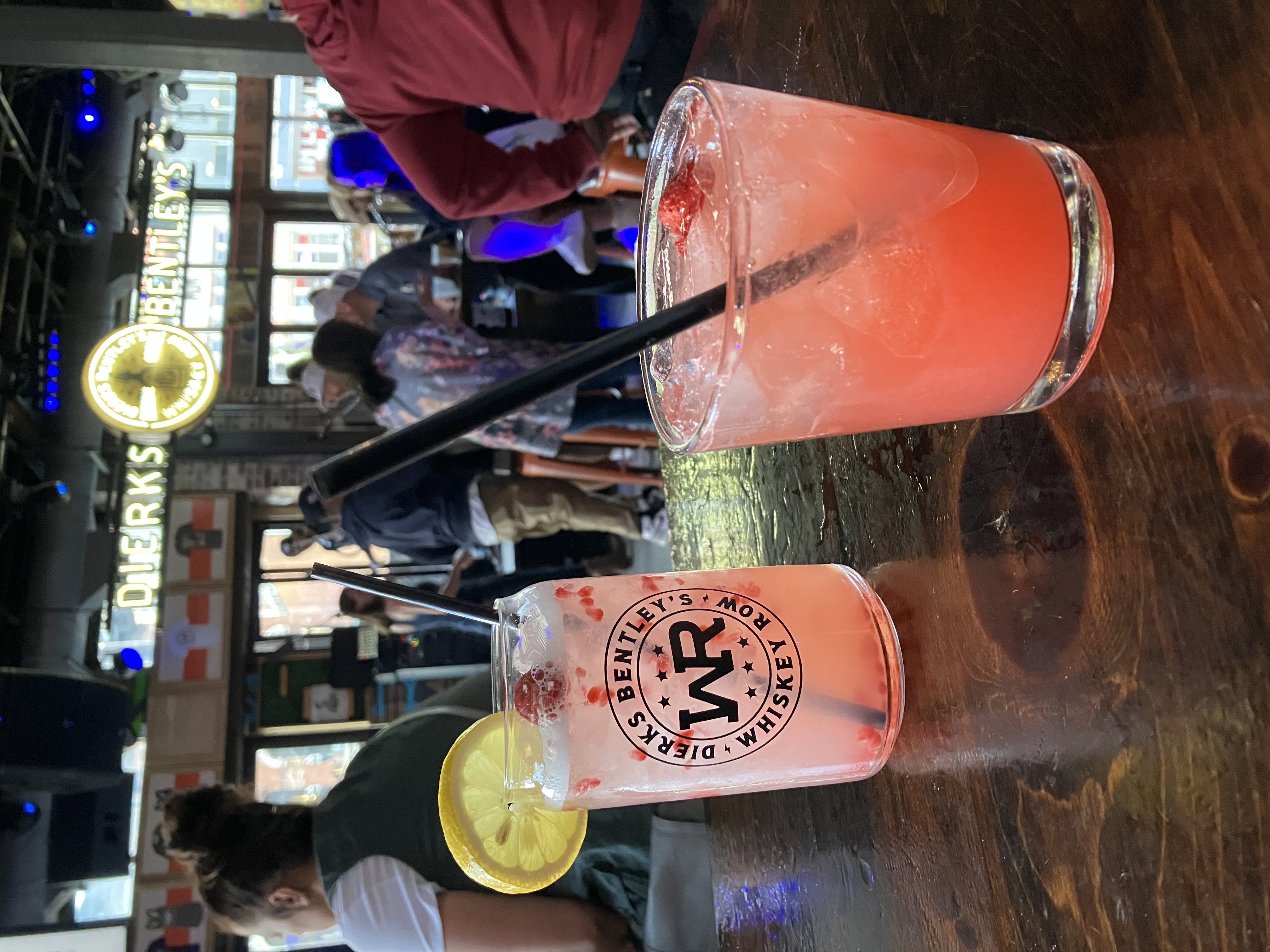 Strawberry margarita on a table with a sign that says Dierks Bentley's Whiskey Row. 