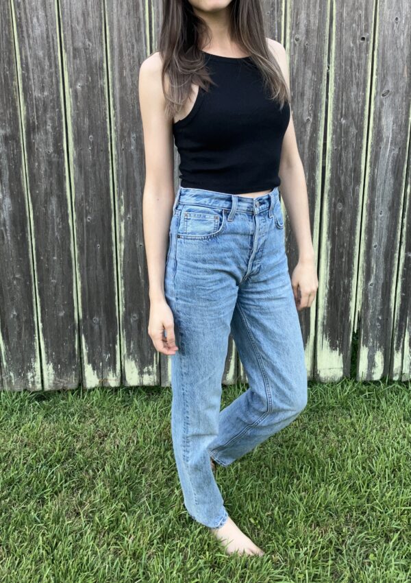 Girl wearing jeans outside in front of a fence. Aritiza jeans review.