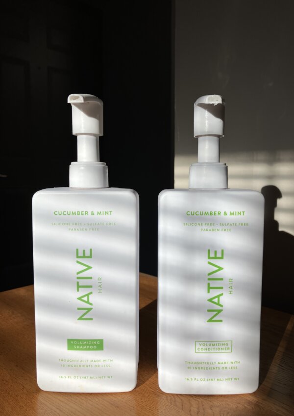 Native Shampoo and Conditioner sitting on a wooden table in the morning light posing for the Native shampoo review.