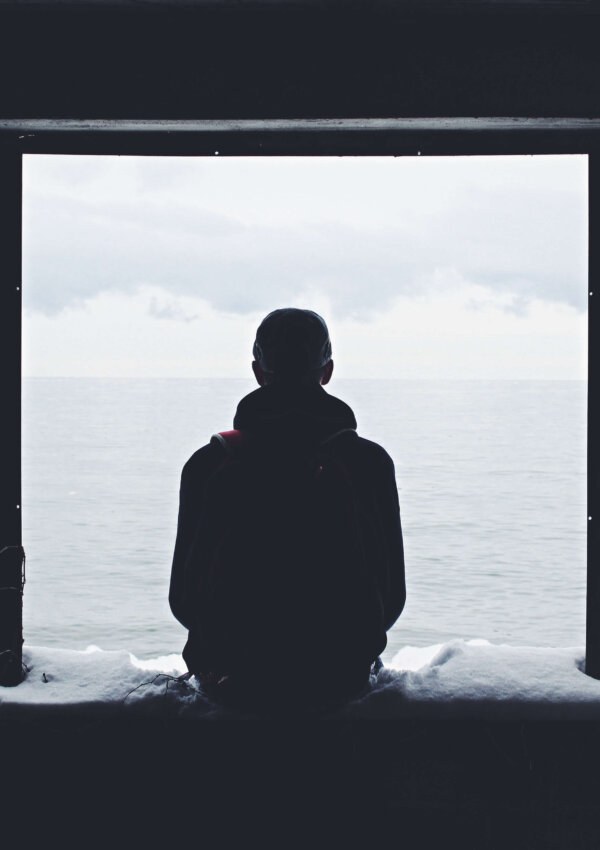 A guy sitting alone on a window.