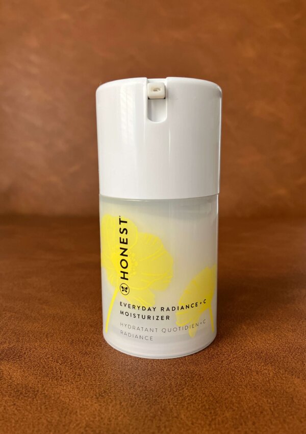 Everyday Radiance Vitamin C Moisturizer sitting on a leather brown background.