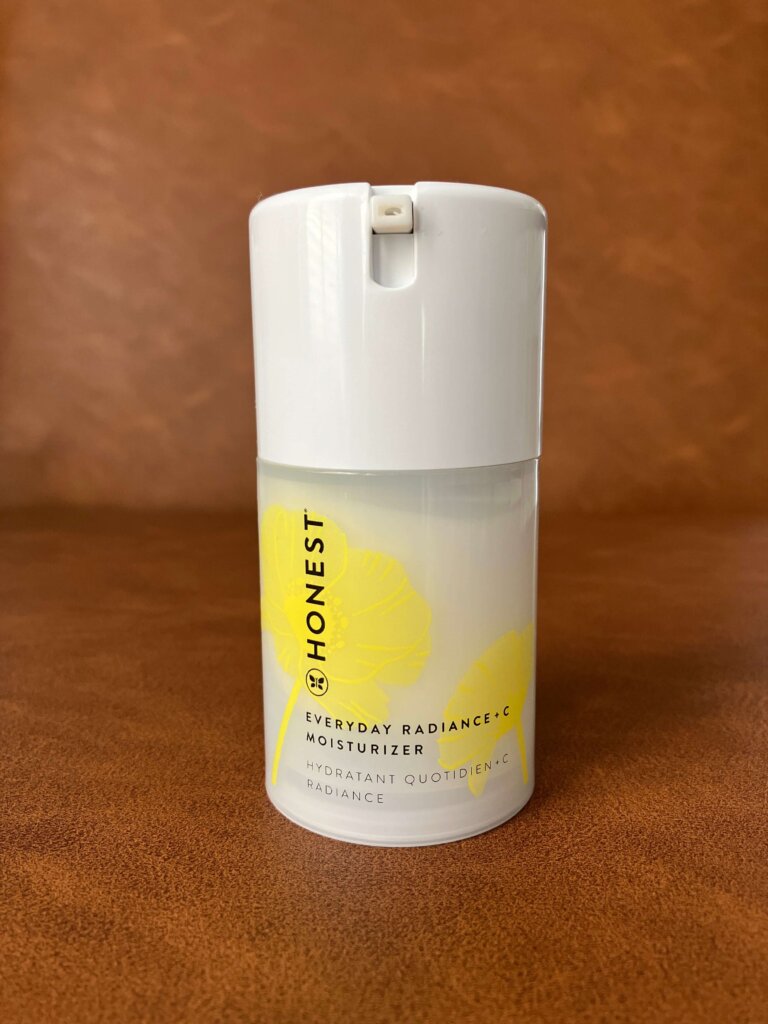 Everyday Radiance Vitamin C Moisturizer sitting on a leather brown background. 
